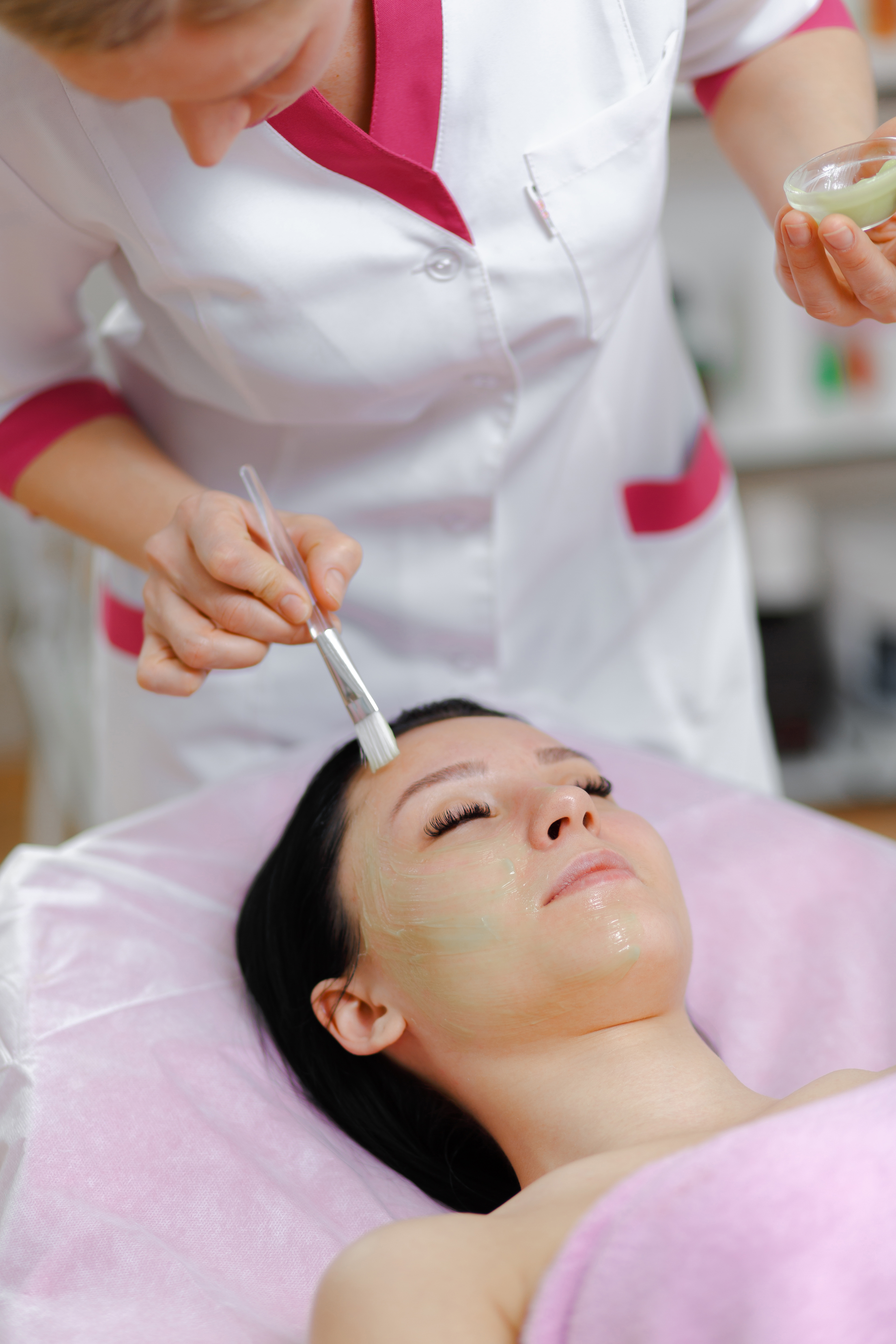 Young beautiful woman with dark hair gets procedure in the beauty salon